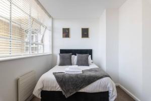 Un dormitorio con una cama con paredes blancas y una ventana en Central 2 Bed Pavilion Apartment en Brighton & Hove