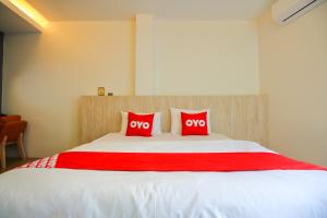 1 dormitorio con 1 cama grande y 2 almohadas rojas en Super OYO 426 All Day Hostel at Sukhmvit en Bangkok