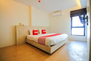 Un dormitorio con una cama con almohadas rojas. en Super OYO 426 All Day Hostel at Sukhmvit en Bangkok