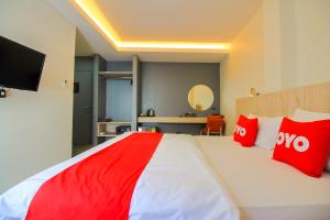 een slaapkamer met een groot bed met rode kussens bij Super OYO 426 All Day Hostel at Sukhmvit in Bangkok