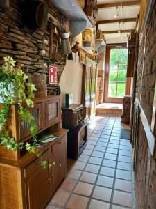 eine Küche mit Fliesenboden und einer Steinmauer in der Unterkunft La Remise - Les Chambres in Neufchâteau