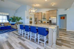 a kitchen with a large island with blue bar stools at Fort Pierce Escape Beach-Entry Pool, Waterslide! in Fort Pierce
