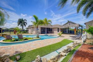 a house with a swimming pool and a playground at Fort Pierce Escape Beach-Entry Pool, Waterslide! in Fort Pierce