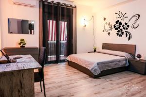 um quarto com uma cama, uma mesa e uma televisão em Casa Grasso em Vittoria