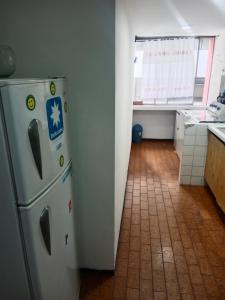 eine Küche mit einem Kühlschrank und Fliesenboden in der Unterkunft Departamento 3 habitaciones in Quito