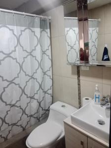 ein Bad mit einem WC und einem Duschvorhang in der Unterkunft Departamento 3 habitaciones in Quito