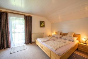 1 dormitorio con cama y ventana grande en Ferienhaus Englacher, en Ebensee