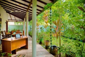 a conservatory with a wooden desk and plants at Nehansa Resort and safari in Tissamaharama