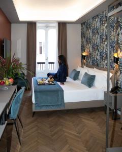 a woman sitting on a bed in a hotel room at Hotel Caravita in Rome