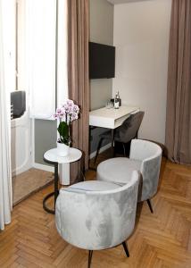 un soggiorno con 2 sedie e un tavolo di Hotel Caravita a Roma