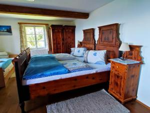 a bedroom with a large wooden bed and a window at Apartments im Almhaus Bachler in Gundisch