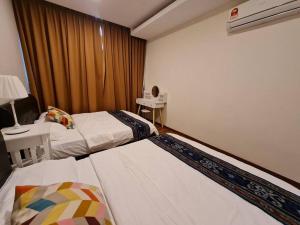 a bedroom with two beds and a desk with a lamp at Lovely VivaMall City View with 2 Card LV11C in Kuching
