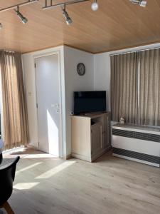 an empty living room with a television and a door at Chalet n°32 in Middelkerke
