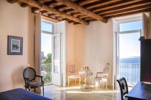 a room with a table and chairs and a balcony at Villa Isabella Minori in Minori