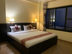 a bedroom with a large bed with a large window at Superview Lodge Sarangkot in Pokhara