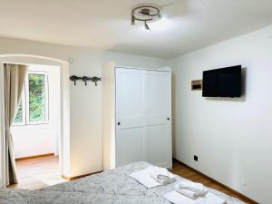 um quarto branco com uma cama e uma televisão em Casa Leone em Lerici