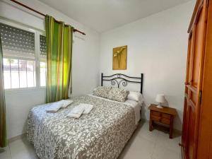 a bedroom with a bed with two towels on it at Apartamento Marinero del Sur in Chiclana de la Frontera