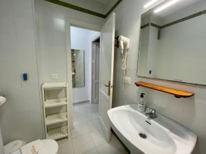 a white bathroom with a sink and a toilet at Apartamento Marinero del Sur in Chiclana de la Frontera