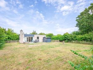a house in a yard with a fence at Cozy holiday home in Den Burg with hot tub in Den Burg