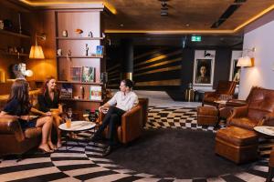 a group of people sitting in a lobby at The Motley Hotel in Melbourne