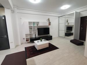 sala de estar blanca con mesa y TV en Tree V House en Chiajna