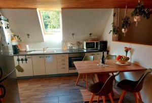 cocina con mesa de madera y sillas en Zelený apartmán Králiky en Králiky