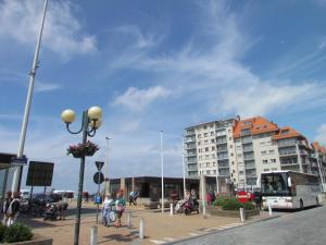 a large building with people sitting in a parking lot at Hotel Uilenspiegel in Nieuwpoort
