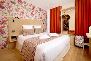 a bedroom with a large bed with red curtains at VLH Montparnasse Eiffel in Paris