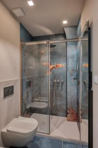 baño con aseo y ducha con mural de pescado en Casa Calleri, en Briaglia