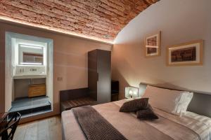 una camera con letto e muro di mattoni di Casa Calleri a Briaglia