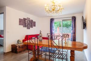 a dining room with a table and a chandelier at Appart - Le Tropical in Ginasservis