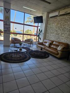 a lobby with a couch and tables and a tv at Atara Hotel in Tiberias