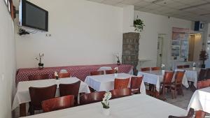 ein Restaurant mit Tischen und Stühlen und einem Fernseher an der Wand in der Unterkunft Atara Hotel in Tiberias
