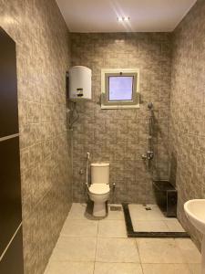 a bathroom with a toilet and a sink and a window at Via broker in Cairo