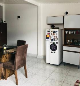 een keuken met een koelkast en een tafel met een stoel bij Casa-Sobrado próximo à Balsa de Ilha Bela e Rodoviária in São Sebastião