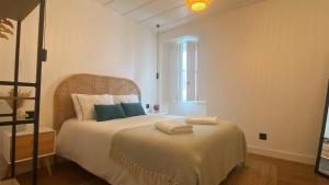 een slaapkamer met een bed met twee handdoeken erop bij Grândola Suites - Suite Henrique in Grândola