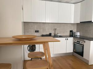 a kitchen with white cabinets and a wooden table at Grândola Suites - Suite Henrique in Grândola