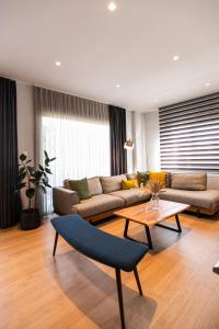 a living room with a couch and a table at AEGLI Central Luxury Apartment in Alexandroupoli