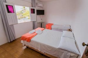 een slaapkamer met een bed en een raam met een raam bij Pousada Paulett's in Ilhéus