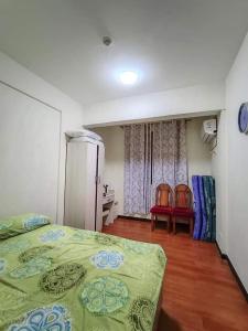 a bedroom with two beds and a table and two chairs at Cheap 2BR Fully Furnished Condo in Davao City in Davao City