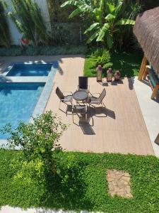 d'une terrasse avec une table et des chaises à côté de la piscine. dans l'établissement Paraiso em Angra dos Reis, à Angra dos Reis
