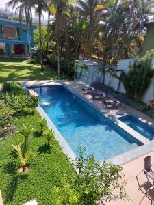 - une piscine dans une cour avec des palmiers dans l'établissement Paraiso em Angra dos Reis, à Angra dos Reis