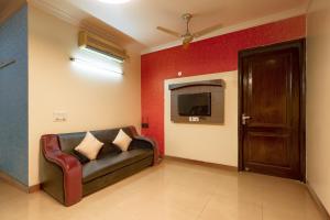 uma sala de estar com um sofá e uma televisão em BED LUCKS near Huda Metro sector 40 em Gurgaon