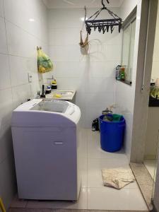 Baño blanco con lavabo y espejo en Apartamento terreo com quintal individual, en Patos de Minas