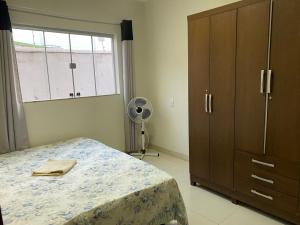 1 dormitorio con 1 cama, vestidor y ventana en Apartamento terreo com quintal individual en Patos de Minas