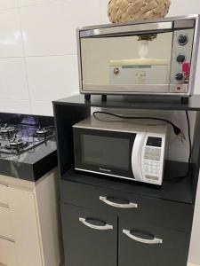 un microondas en la parte superior de un mostrador en la cocina en Apartamento terreo com quintal individual, en Patos de Minas