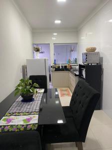 a kitchen with a black table and chairs and a kitchen with at Apartamento terreo com quintal individual in Patos de Minas