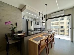 una cucina con tavolo, sedie e piano di lavoro di Moderno Flat Rio - Alto Padrão - Posto 6 a Rio de Janeiro