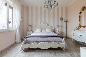 a bedroom with a white bed and a chandelier at Annali Casa vacanze - Shabby style nella natura in La Spezia