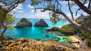 a view of a beach with rocks in the ocean at Pousada Algas Marinhas in Fernando de Noronha